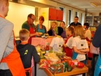 underviser på Fars køkkenskole Jens Augustesen og Minna Elisabeth Pedersen med rødt og blåt forklæde sammen med resten af holdet.