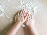 Top view shoot of children's hands make dough on the table